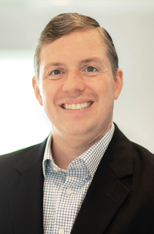 Andrew Ryan smiling in a bright, modern office